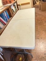 Full view of 6-ft folding table showing tabletop, legs, and surrounding area
