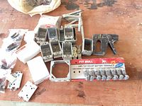 All items laid out: junction boxes, battery terminals package, mounting brackets, faceplate, clamp, screws