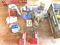 Overall layout of lot showing batteries, rigging hook, hardware packs, gloves, jar of screws, crate with cords