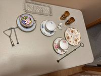 Group shot displays teacups, saucers, relish dish, crystal tray, wood shakers, metal tools