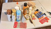 Overall view of sprays, glues, files, tools and wood pieces on table