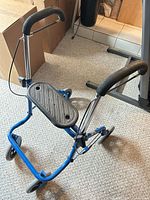Side view of blue rollator walker showing seat platform, wheels, handle grips and brake cables