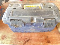 closed blue/black toolbox showing broken latch and dirt