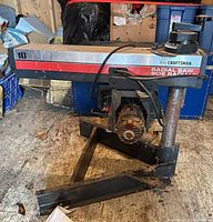 Full view of Craftsman radial arm saw on metal stand showing motor, column, and overall wear