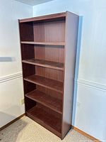 front angled view of tall dark brown laminate bookcase