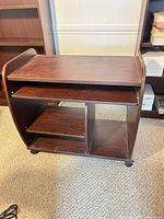 Full view of desk cart showing top surface, keyboard tray, shelves, and casters