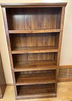 Front view of entire dark brown engineered wood bookcase showing five shelves and two stacked sections