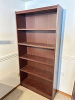 Full view of dark cherry bookcase showing five shelves