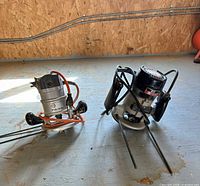 Both routers standing on floor with guide rods attached and cords visible