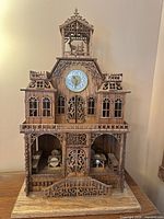 Front view of full chalet clock showing analog face and carved woodwork