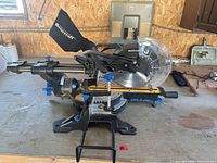 Left side view of Mastercraft sliding compound miter saw with dust bag, blade guard and rails visible