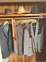 Sport coat, hat and belt hanging in closet