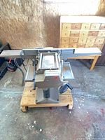 Front view of MEW jointer/planer on dolly with fence and hose visible