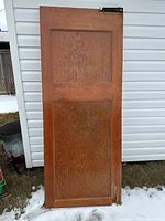 Full view of one oak two-panel door showing wood grain and overall condition
