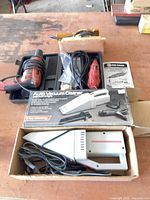 Lot overview showing drill, rotary tool, sander, auto vacuum, case and manual