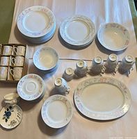 Full set laid out showing plates, bowls, cups, platter and small dish