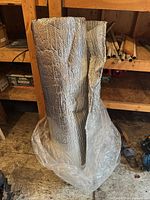 Roll of reflective insulation standing upright in workshop