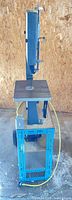 Full side view of band saw on blue wheeled stand