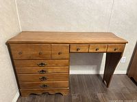 Front angled view of desk showing four drawers, hardware, knee space