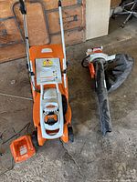 Mower, blower-vacuum with bag, charger on floor