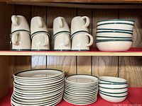 Mugs, plates and bowls stacked on shelf