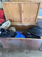 Open plywood trunk showing interior and contents