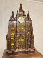 Full front view of wooden cathedral clock showing overall structure and dial