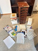 Wooden mail sorter surrounded by assorted stationery packs, envelopes, loose paper and cardstock