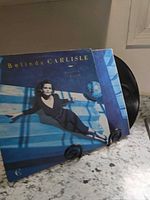 Front album cover on display stand with vinyl partially visible