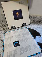 Front jacket displayed upright with lyric sleeve and vinyl visible