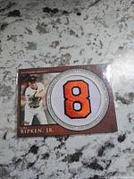 Front of Topps Cal Ripken Jr. patch card showing photo and embroidered number 8