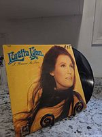 Front cover showing album title and artist with vinyl partially visible