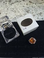 Ring with storage boxes on display pad