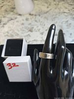 Ring on mannequin hand and ring box to show appearance and finish