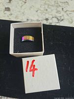 Ring in box showing rainbow finish and leaf engraving