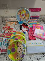 Group shot of all party supplies, toys, CDs and book on countertop