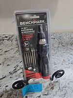 Front view of sealed Benchmark 14-in-1 ratcheting screwdriver set showing handle and bits