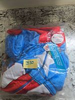 Front of sealed package showing folded blue/red/white onesie and size tag