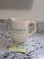 Front view showing Usher's Scotch Whisky text and jug form