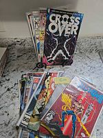 Front view of all comics showing Crossover #1 on stand and stacked bagged issues including Hellstorm #1 and Marvel 50th Anniversary border comics