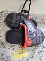 Pair of Darth Vader slippers showing overall design and tags
