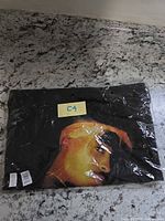 Bag sealed in plastic with colour portrait partially visible