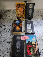 All three VHS sleeves and tapes arranged on countertop