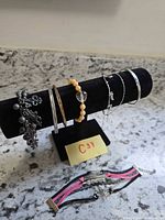 All seven bracelets displayed on velvet stand and countertop