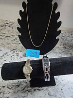 Overall view showing chain necklace and two wristwatches on displays