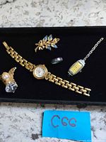 Group shot of five jewelry pieces on black tray