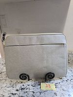 Front view of grey padded laptop case on stand