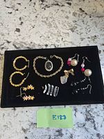 All jewelry pieces arranged on black tray