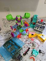 Overview of assorted Batman toys including Joker figure, bat-plane, console, yellow bat item, storage case and accessories