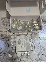 Overview of shoebox holding glass holders and bag of candles